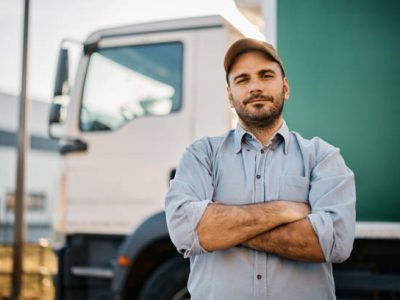 Portrait of confident truck driver on parking lot looking at camera. Copy space.